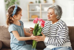 mujer recibiendo flores de una niña